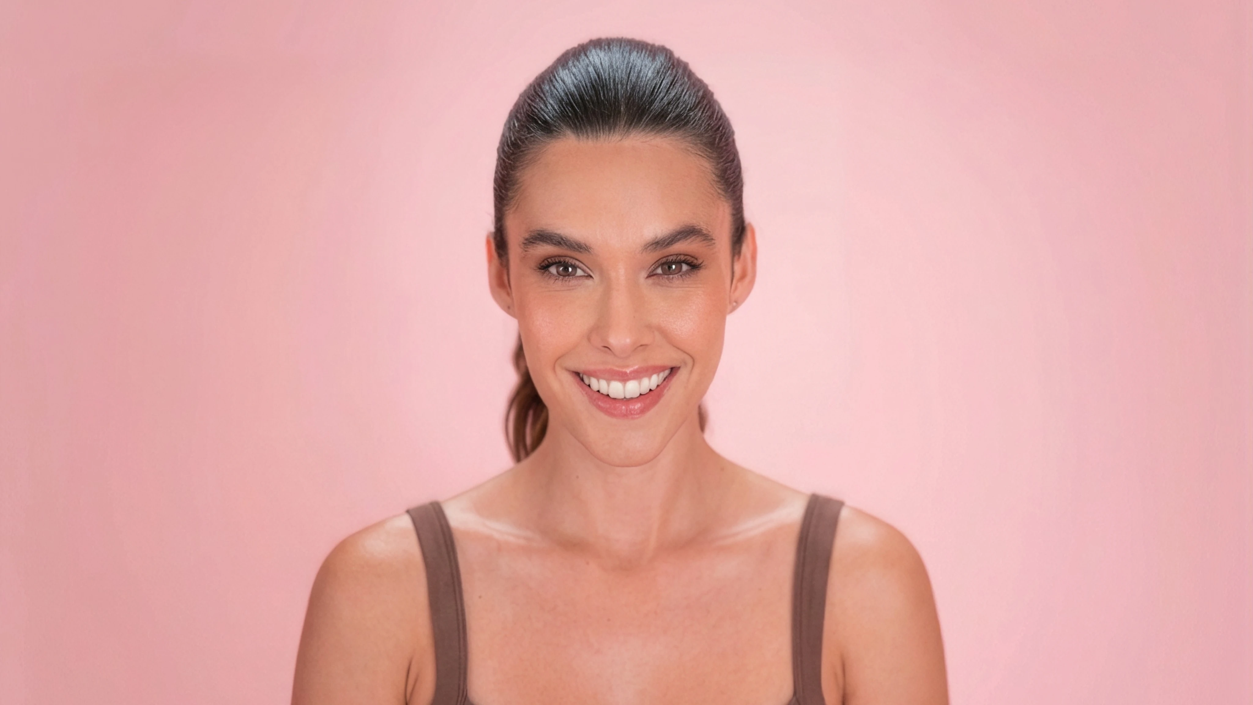 Silvy Araujo sonriendo, con ropa de entrenamiento y fondo rosa